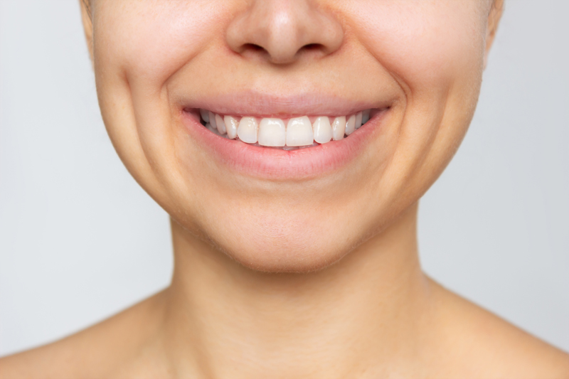 cropped shot of young caucasian woman with perfect white even teeth isolated on white background