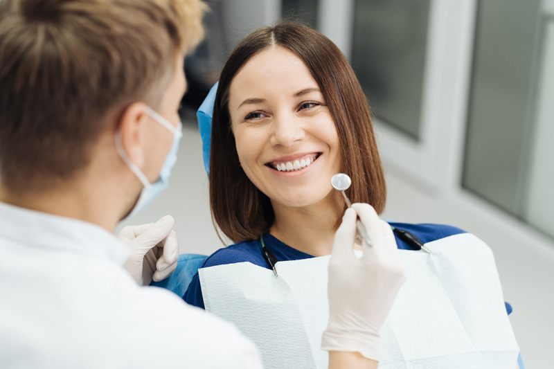 male professional dentist with gloves and mask and discuss what the treatment will look like of the patient s teeth