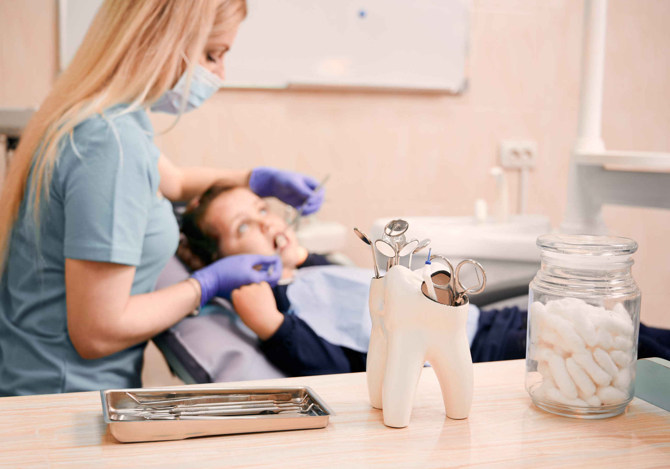 dentist examining kid teeth in cabinet with dental instruments scaled
