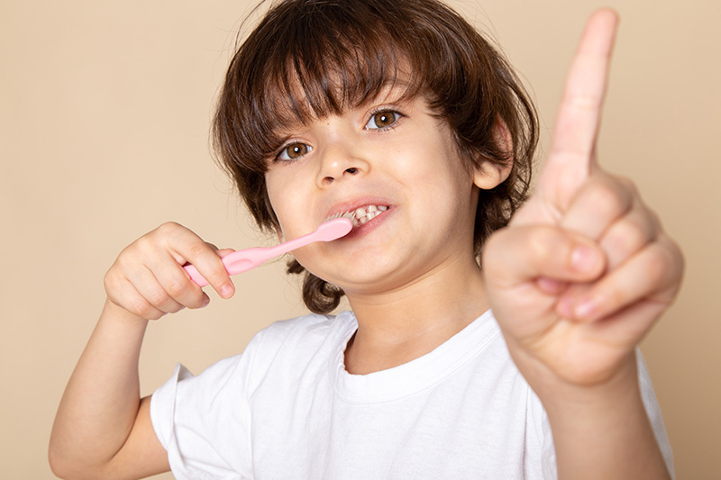 a front close up portrait view cute boy adorable cleaning his te