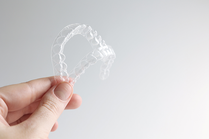 Persona sostiene invisalign