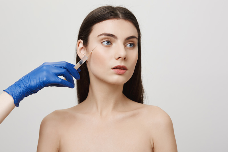 woman in beauty salon look away receive bottox face injection with syringe