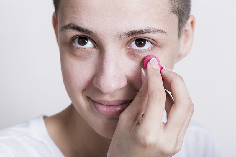 mujer aplicando crema ojeras
