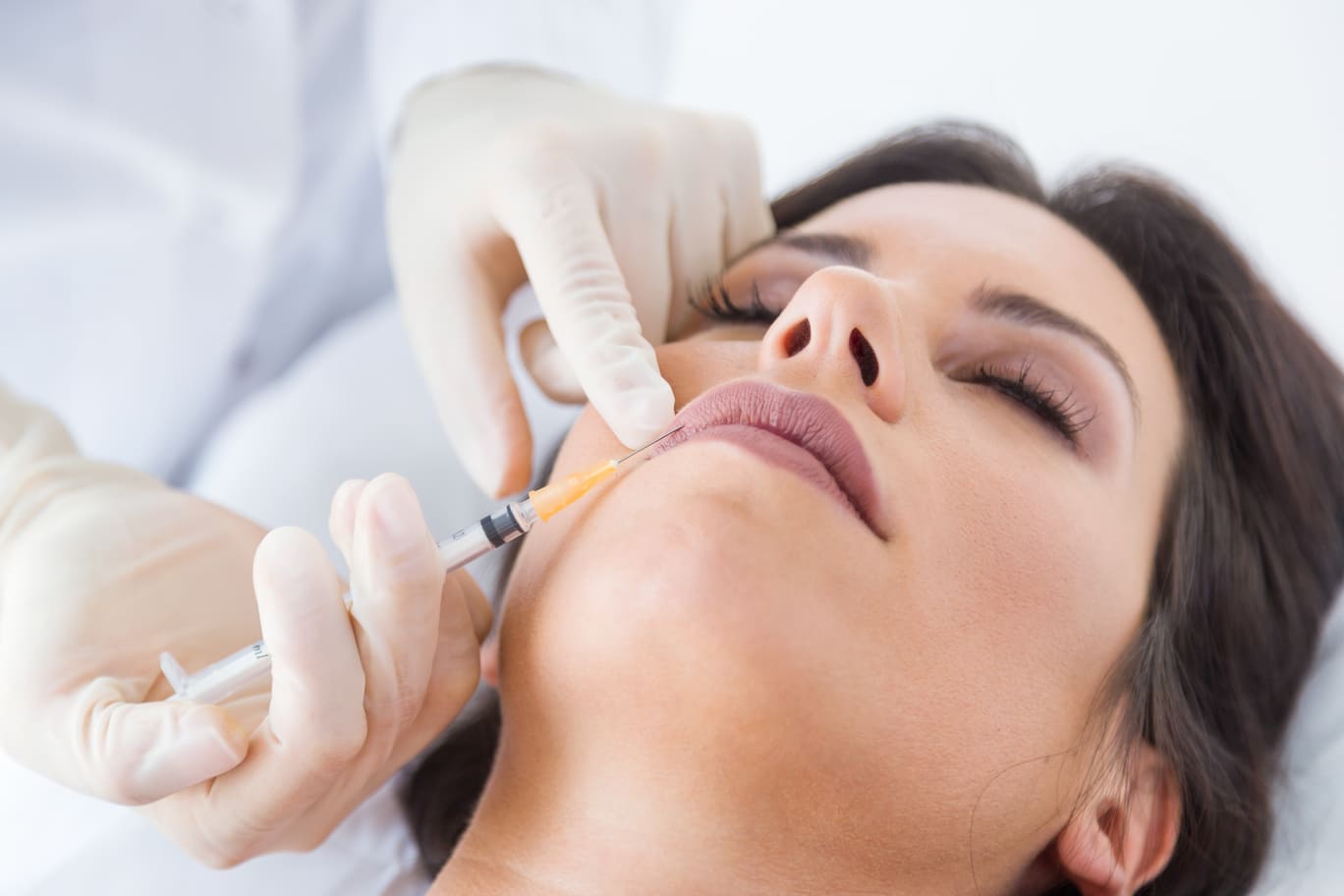 beautiful young woman getting botox cosmetic injection in her face